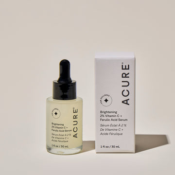 Brightening 2% Vitamin C+ ferulic Acid Serum galss botlle next to its packaging labeled ACURE including product details